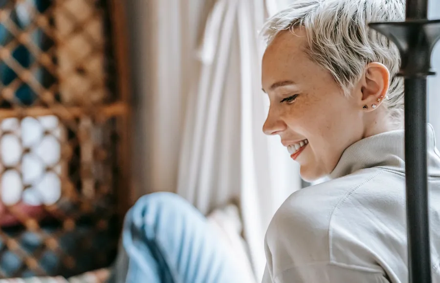 Donna che sorride di profilo alla luce di una finestra